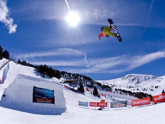 Snowboarder jumping of a ramp in the el tarter snow park and ski slopes of el tarter